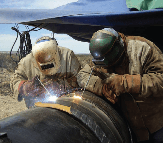 Certified welders performing pipe welding on-site